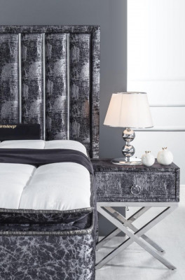 Black bed with mattress and two bedside tables in the bedroom furniture set